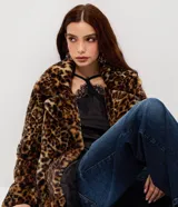 Campera corta de pelo sintético con estampado animal print de leopardo. Presenta un diseño estructurado con cuello amplio y solapas, ideal para un look sofisticado.