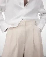 Pantalón ancho de lino y algodón color beige, con cintura elástica en la espalda, doble pinza en el delantero y bolsillos laterales.