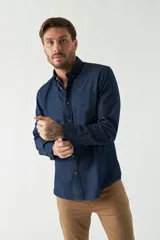 Camisa de jean azul con fit regular, manga larga, logo bordado, bolsillo y cartera con botones.