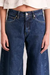 Pantalón de jean azul oscuro, de corte wide leg y tiro alto.