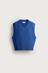 Chaleco de punto trenzado color azul, de corte relaxed fit, con cuello en V y sisas acabadas en rib.