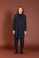 Chaqueta larga de silueta amplia con cuello de solapa, cierre frontal de botones y bolsillos laterales con solapa. Está confeccionada en tejido de algodón con un sutil diseño de cuadros.