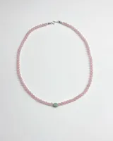 Collar de cuentas de cuarzo rosa con una piedra central verde y cierre de plata.