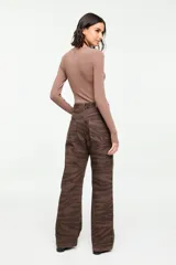 Jean flare de tiro alto con estampado animal print en tonos marrón, diseño clásico de cinco bolsillos y corte recto.