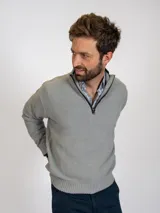 Sweater gris claro de tejido de punto con medio cierre frontal y cuello alto.