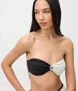 Top de bikini bandeau de microfibra con diseño color block en color negro y blanco, fruncido central y detalle metálico.