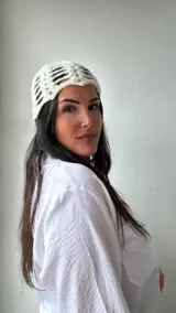 Gorro tipo turbante de tejido crochet color crudo, con diseño calado y lentejuelas plateadas.