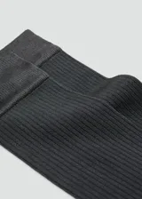 Medias largas de tejido de canalé en color gris oscuro, con diseño elástico y ajustado.