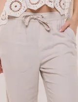 Pantalón de lino blanco, marca Dash, con pretina ancha elastizada, lazo de ajuste y bolsillos inclinados en el frente.