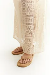 Sandalias negras de cuero sintético con tachas doradas, tiras cruzadas y ajuste con hebilla dorada en el tobillo.