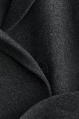 Abrigo midi de paño en color gris oscuro, con solapas de muesca, cierre oculto con botones a presión y cinturón ajustable a la cintura. Presenta bolsillos laterales discretos, abertura trasera y forro interior.