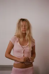 Top de manga corta color beige melange, con escote redondo y diseño cruzado frontal que simula un doble uso con detalle de lazo en el pecho.