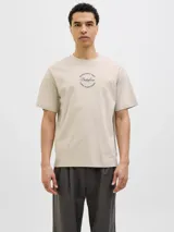 Remera color crema de corte recto y mangas cortas, con cuello redondo. Estampado en la espalda con un dibujo de una calle con edificios, palmeras y un auto amarillo.