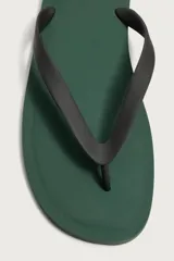 Sandalia de goma color negro, de diseño plano y tiras delgadas en el empeine estilo ojota.