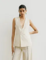 Chaleco sastrero color crema de lino, con cuello en V profundo y cierre cruzado con botón.