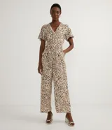 Mono largo de viscosa con estampado animal print jaguar, escote en V, cierre frontal con botones, mangas cortas, cintura con lazo ajustable y bolsillos laterales.