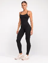 Monopieza deportivo negro con breteles finos, espalda escotada con detalle cruzado y diseño largo hasta los tobillos, confeccionado en poliamida de alta performance.