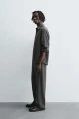 Pantalón de corte relaxed fit, con cintura ajustable, bolsillos delanteros y bolsillo trasero de plastrón. Presenta cierre frontal con cremallera y botón.