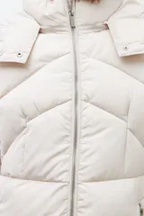 Campera puffer de corte largo y diseño capitoneado, con capucha desmontable y cierre frontal completo. Presenta bolsillos laterales con cierre y puños elásticos.