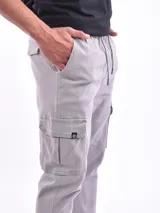 Pantalón jogger cargo color verde militar con cintura elástica ajustable con cordón, bolsillos laterales y bolsillos cargo con solapa en los muslos.