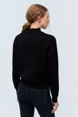 Sweater gris de lana con cuello alto.