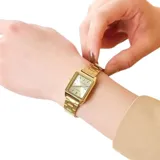 Reloj analógico Casio para mujer, con caja y pulsera de eslabones de acero inoxidable color dorado. La esfera es rectangular de color dorado claro, con marcadores de hora en relieve y manecillas doradas. Presenta la inscripción "WATER RESIST" en la parte inferior de la esfera.