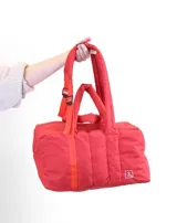 Bolso tipo tote color beige con diseño acolchado y doble asa de hombro.