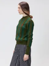 Sweater de punto con cuello polera, diseño de rayas verticales en tonos verdes, puños y bajo acanalados, y detalle de bordado pequeño en el pecho.
