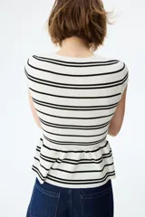 Saco ajustado en punto fino suave, de color blanco con rayas negras, cuello redondo, manga japonesa, botones hasta la cintura y peplum acampanado.