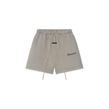 Short de felpa Fear of God Essentials, color gris, con cintura elástica con cordón ajustable largo, bolsillos laterales y el texto "Essentials" bordado en la pierna izquierda.