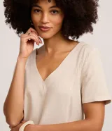 Vestido corto t-shirt de Marfinno confeccionado en viscolino color beige, con escote en V, mangas cortas y estampa en la parte inferior con motivos arquitectónicos y de palmeras en azul marino.