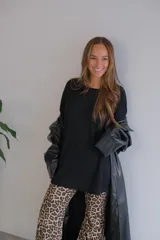 Conjunto de dos piezas compuesto por un buzo de cuello redondo y mangas largas con diseño holgado y un pantalón de corte recto y tiro alto. Ambas prendas están confeccionadas en tejido de punto acanalado.