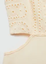 Vestido midi de algodón color crema con diseño bordado tipo broderie. Presenta escote cuadrado, tirantes finos, aberturas laterales cut-out en la cintura y cierre lateral de cremallera.
