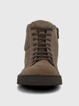 Botín de cuero gamuzado color marrón, con diseño acordonado y suela de poliuretano texturizada. Presenta una caña baja y un estilo casual y versátil.