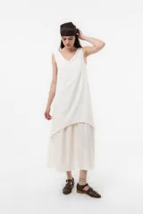 Vestido largo color tostado con silueta relajada, escote en V, sin mangas y diseño de falda en capas. Cuenta con un lazo fino regulable en la cintura.