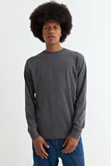 Remera de manga larga con cuello redondo, confeccionada en tejido de algodón y poliéster, con diseño básico y ajuste estándar.