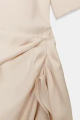 Vestido midi de Zara Woman Collection, confeccionado en mezcla de viscosa, con cuello redondo, manga corta y detalle de drapeado lateral con volado. Presenta bajo asimétrico y cierre en la espalda.
