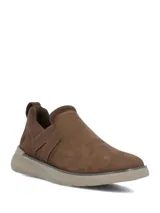 Zapatillas tipo slip on color marrón con inserciones elásticas laterales cruzadas y suela de goma en tono tostado.