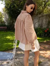 Camisa celeste de denim con bordado de hojas en las mangas, cuello con volados y botones de flor.