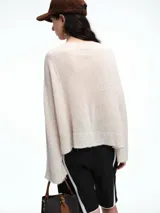 Sweater de punto negro con lentejuelas sutiles, de corte holgado, hombros caídos y mangas largas con terminación acampanada.