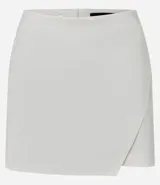 Short pollera corto de tiro alto, confeccionado en bengalina, con diseño de recorte delantero y cierre invisible en la parte posterior.