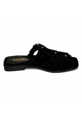 Zueco de gamuza negra con diseño trenzado tipo fisherman, hebilla metálica dorada y tachas decorativas.