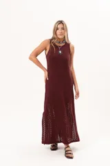 Vestido largo de tejido calado color bordó, de silueta recta, escote redondo y sin mangas, con aberturas laterales en el bajo.