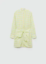 Vestido camisero corto con estampado de cuadros amarillos y celestes. Tiene cuello mao, mangas largas con puños abotonados y cierre frontal con botones. Incluye lazo decorativo en la cintura.