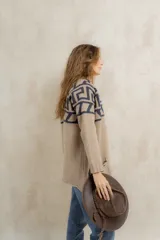 Saco tejido de punto con diseño de guarda inca en la parte superior. Presenta bolsillos frontales con detalles de tiras de cuero y flecos. De corte recto y largo medio, con terminaciones en tejido acanalado.