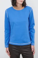 Remera de manga larga con cuello redondo, confeccionada en tejido de punto gris melange con costuras visibles en contraste.