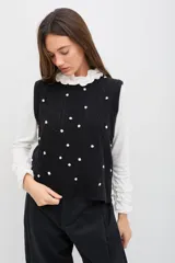 Polera de manga larga color azul jaspeado, con cuello alto y puños decorados con volados. Presenta un calce cómodo y relajado.