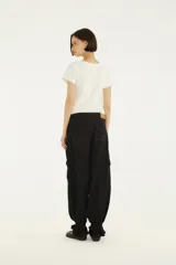 Pantalón cargo de denim negro con pespuntes en contraste, bolsillos laterales con solapa, corte relajado y terminaciones ajustables en los tobillos.