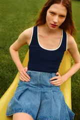 Musculosa corta de punto de algodón, color azul marino, con escote redondo profundo y ribete blanco en el escote y sisas.