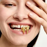 Anillo dorado con forma de alas de ángel, fabricado en aleación de metales y bañado en oro de 18k.